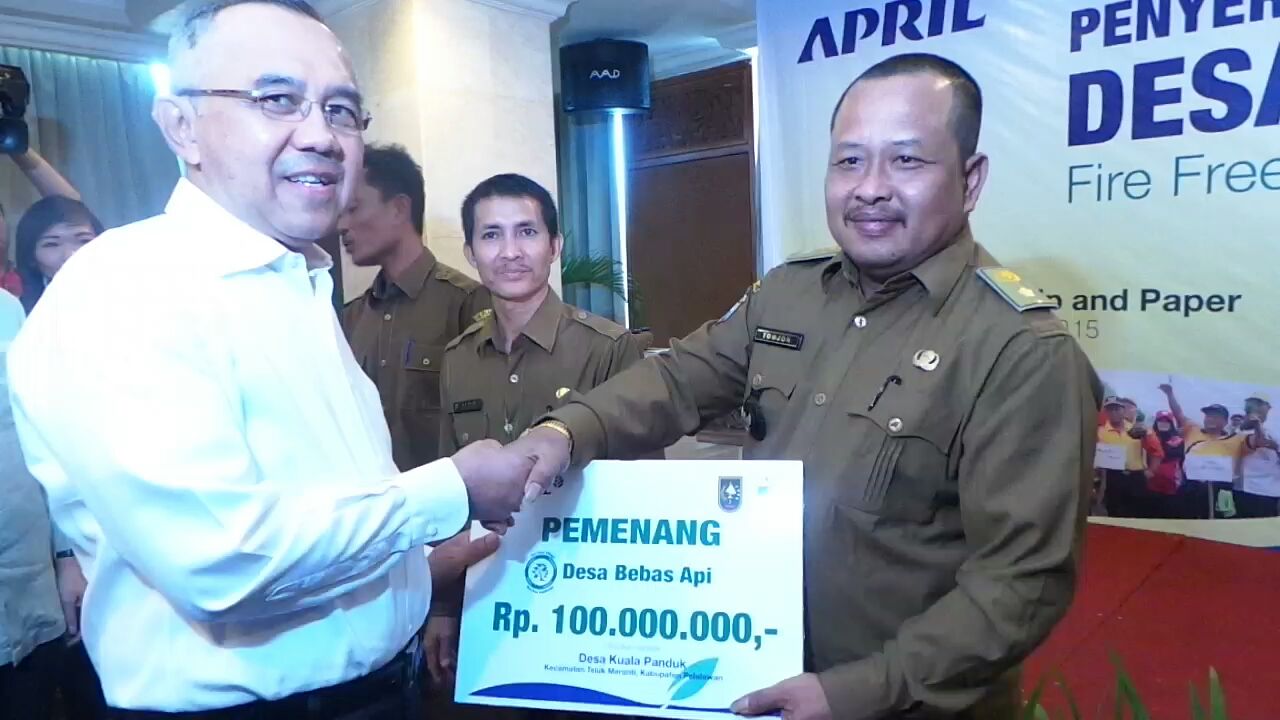 Riau Interim Governor, Arsyadjuliandi Rachman, presents a Fire Free Village Programme award to Kuala Panduk village chief, Tomjon. 