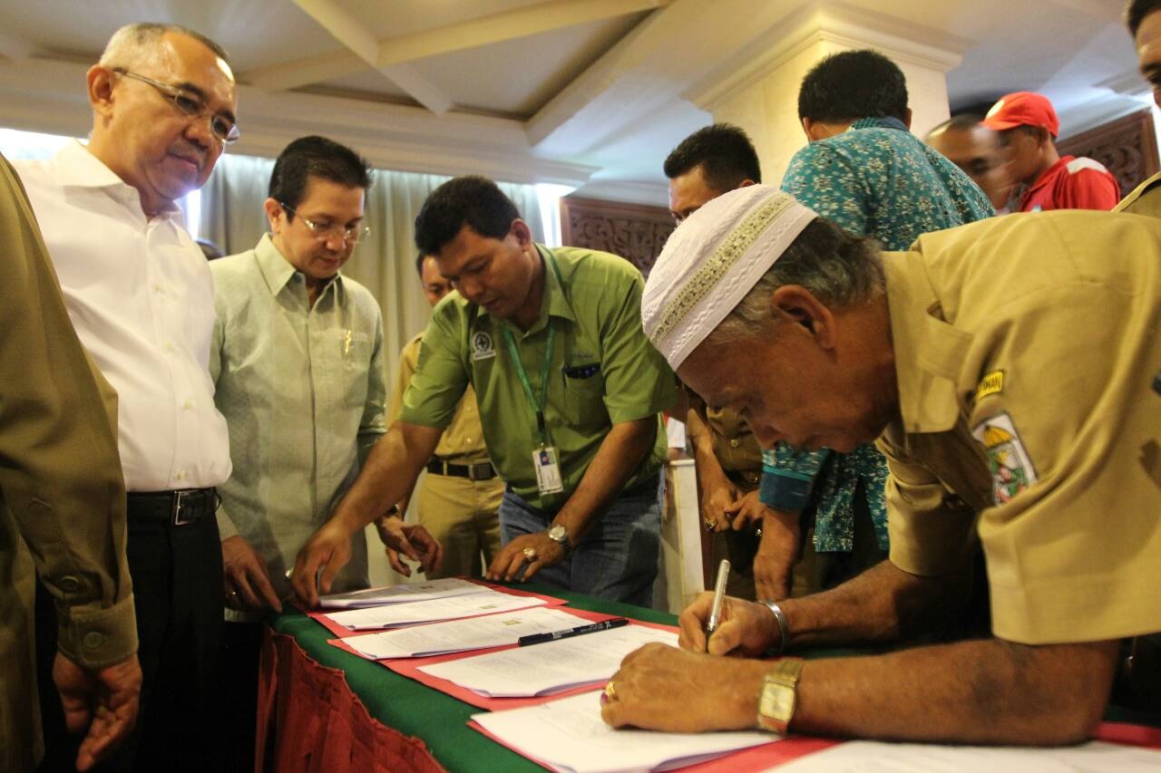 Yunus, kepala desa Sering, menandatangani perjanjian kerjasama bersama dengan 8 desa lainnya, menegaskan kembali partisipasi mereka dalam Program Desa Bebas Kebakaran, disaksikan oleh Plt. Gubernur Riau Arsyadjuliandi Rachman dan Direktur Pelaksana APRIL, Tony Wenas 